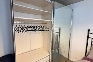 A room with a sliding glass door closet, a bed with a metal frame, and a white wall. - Studio Happy Life - peace, mountain views & perfect location near Interlaken (Blumenstein)