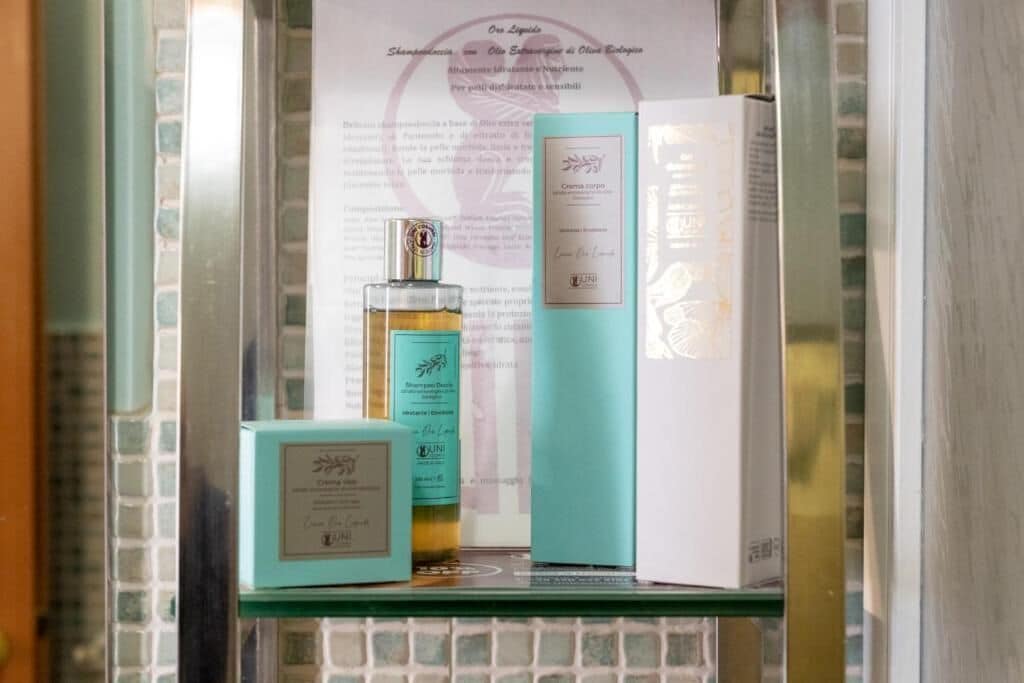 Exhibición de productos para el cuidado de la piel sobre una estantería, con un fondo de pared de azulejos y un texto enmarcado.