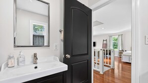 A bathroom with a white sink, dark cabinets, and a black door. - Relaxing stay near Louisville's top attractions! (Louisville)