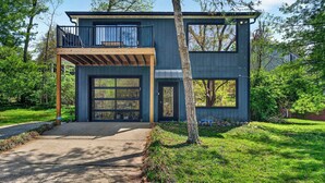A modern two-story house with a balcony, large windows, and a wooden deck. - Relaxing stay near Louisville's top attractions! (Louisville)