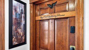 A wooden door with a plaque that reads 'My Old Kentucky Home' and a framed cityscape painting on the adjacent wall. - Exclusive one-story retreat close to attractions! (Louisville)