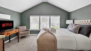 A bedroom with a bed, a TV, a chair, and a ceiling fan. - Spacious home w/ yard near Downtown attractions! (Louisville)