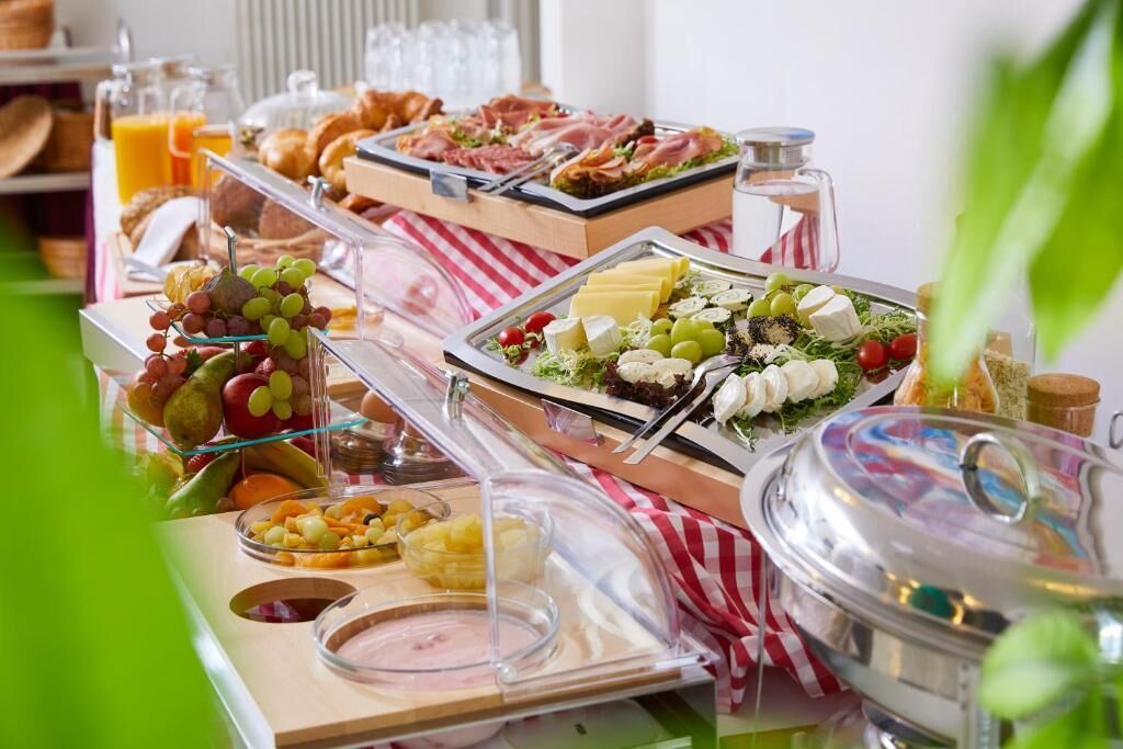 A buffet with various food items and a glass of orange juice.