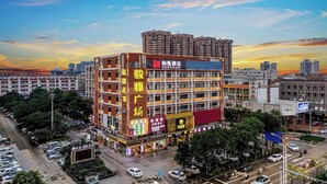 A multi-story hotel with a prominent sign, surrounded by other buildings and a parking lot. - Borrman Hotel Foshan Nanhai Junya Plaza (Foshan)