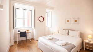 A bedroom with a bed, a desk, a chair, a round mirror, and two framed pictures on the wall. - FLH Restauradores Bright & Chic Flat with Balcony (Lisboa ciudad)