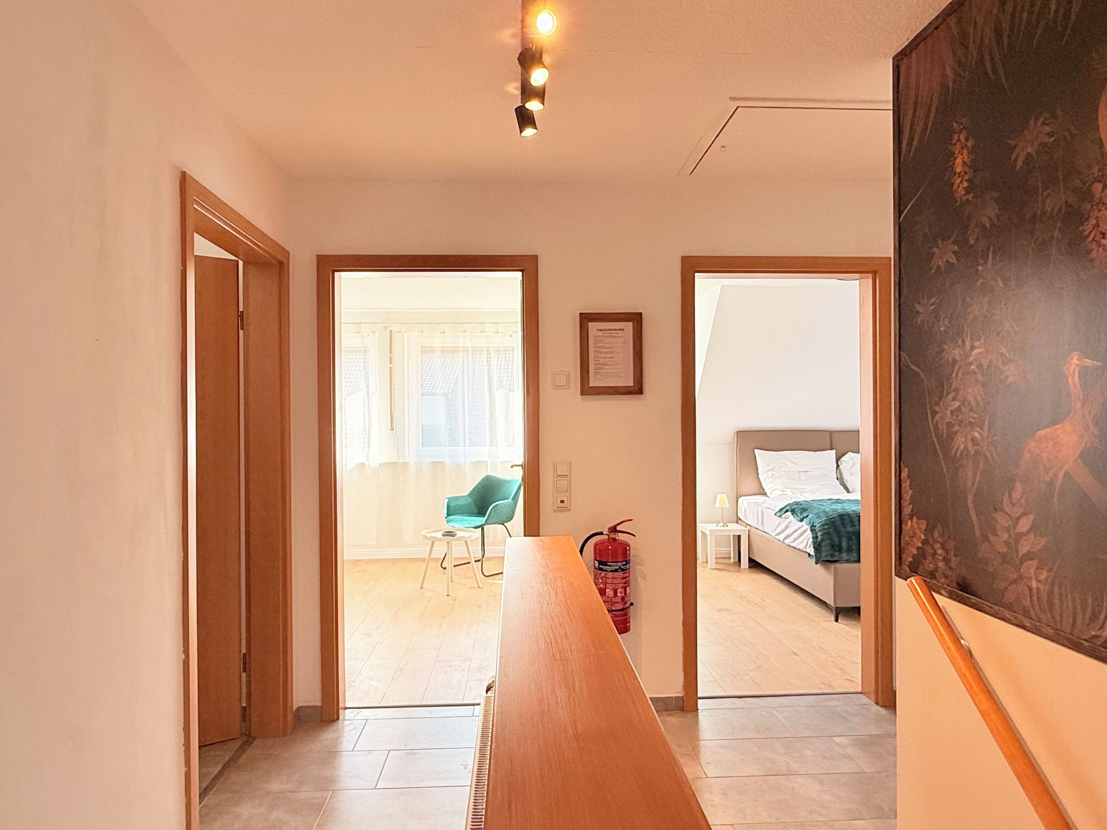 Ein Hotelzimmer mit Bett, Sessel, Tisch und einem Bild an der Wand.