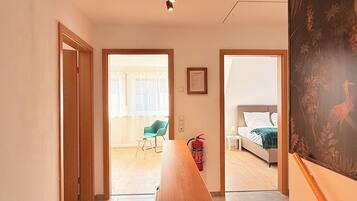 Ein Hotelzimmer mit Bett, Sessel, Tisch und einem Bild an der Wand.