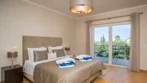 A bedroom with a bed, nightstands, a lamp, a balcony with a view.