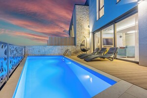 A swimming pool with lounge chairs, a stone wall, and a sunset view. - Ultra-modern vacation home for 6 with swimming pool in Crikvenica (Crikvenica)