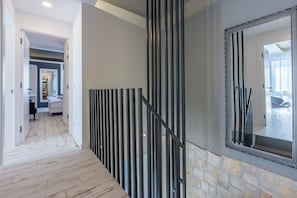 A hallway with a wooden floor, a stone wall, and a large mirror with a black frame. - Ultra-modern vacation home for 6 with swimming pool in Crikvenica (Crikvenica)