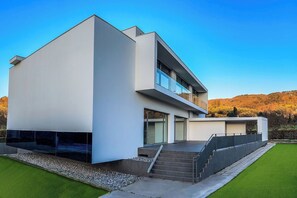 A modern two-story house with a flat roof, large windows, and a balcony. - Beautiful private villa for 10 guests with A/C, WIFI, private pool, TV and patio, close to Arezzo (Subbiano)