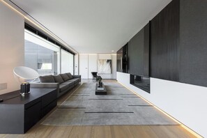 Un salon moderne avec un canapé, une table basse et un téléviseur.