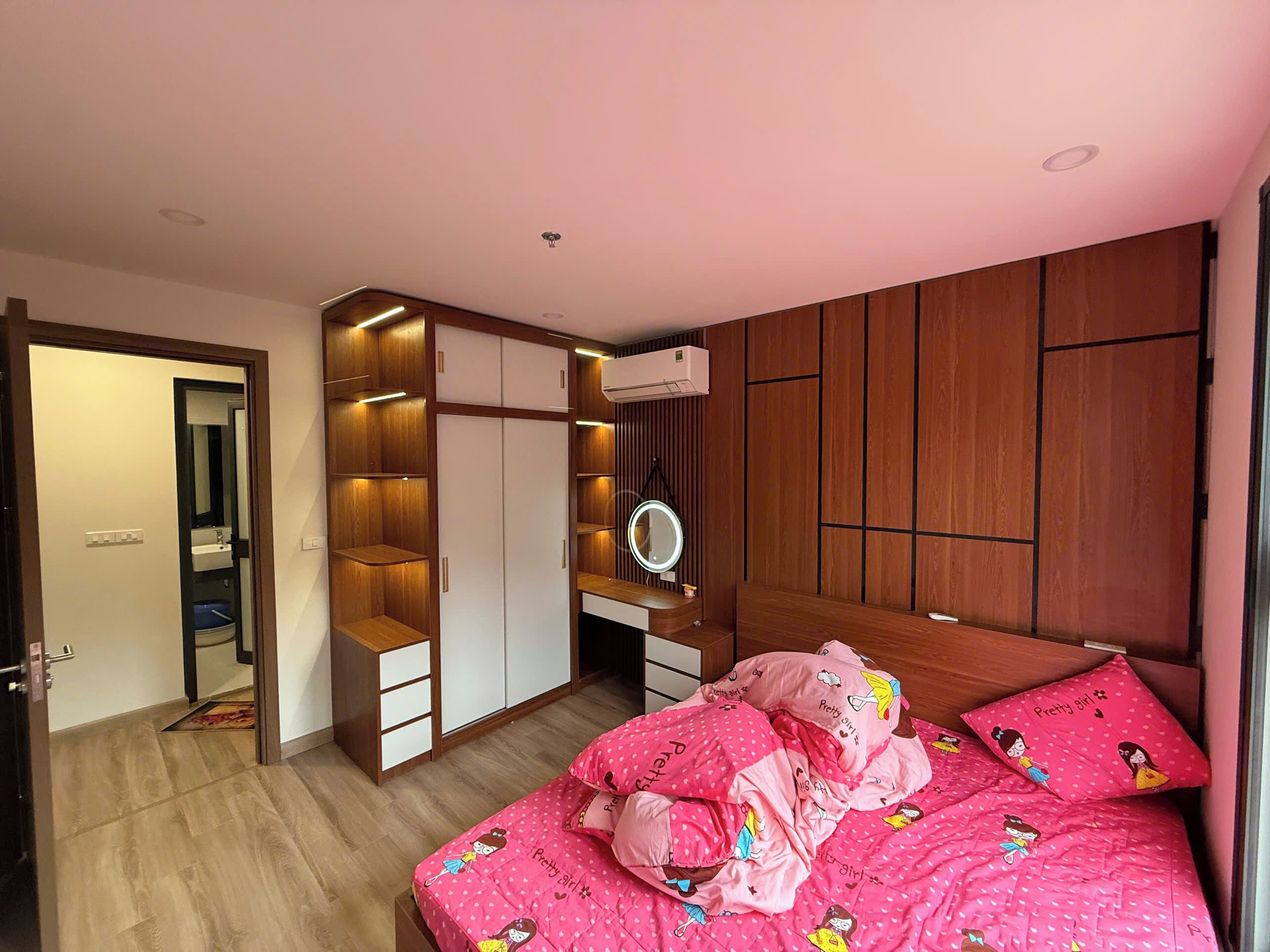 Une chambre à coucher avec un lit, une armoire, un miroir et une salle de bain.