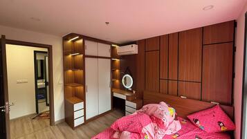 Een slaapkamer met een bed, een kledingkast, een spiegel en een badkamer.