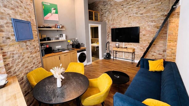 Un espace de vie compact comprenant une cuisine, un coin repas et un espace détente.