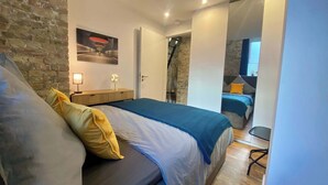 Une chambre à coucher avec un lit, une table de chevet, une lampe et un miroir.