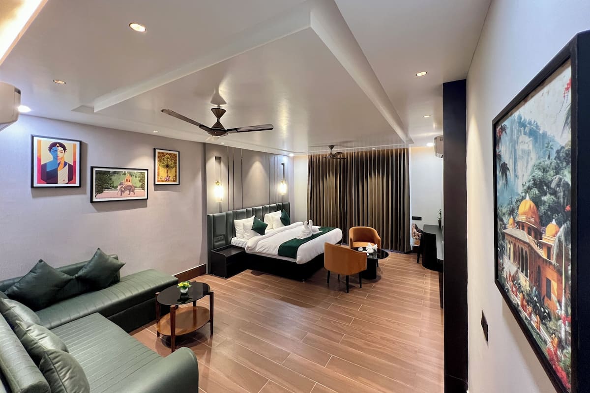 Una habitación de hotel moderna con cama, sofá y zona de comedor.