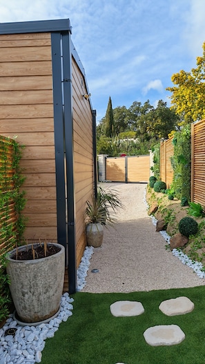 A garden pathway leading to a wooden building with a gravel path and stepping stones. - Luxurious cottage with private pool and spa in the Canebières estate in Le Muy. (Le Muy)