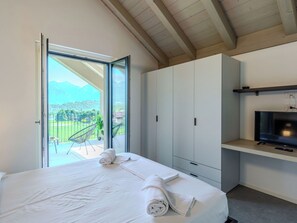A bedroom with a bed, a TV, and a balcony with a mountain view. - Stunning private villa with WIFI, A/C, private pool, TV, terrace, pets allowed and panoramic view (Colico)