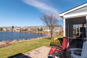 Une terrasse avec vue sur un lac et des maisons en arrière-plan.