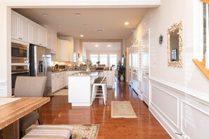 A spacious kitchen with white cabinetry, stainless steel appliances, and a central island. - Waterfront Resort | Community Amenities | Sleeps 13 (Selbyville)