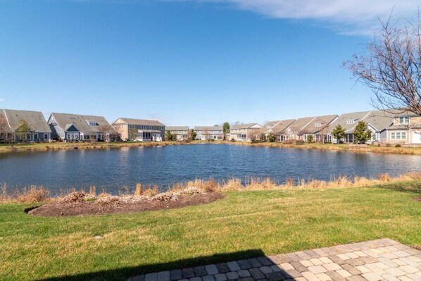 A row of houses with a lake in the foreground. - Waterfront Resort | Community Amenities | Sleeps 13 (Selbyville)