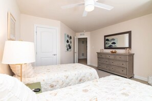 A bedroom with two beds, a dresser, a ceiling fan, and artwork on the walls. - Waterfront Resort | Community Amenities | Sleeps 13 (Selbyville)