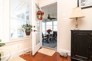 A doorway leading to a dining area with a table and chairs, a ceiling fan, and a potted plant. - Waterfront Resort | Community Amenities | Sleeps 13 (Selbyville)