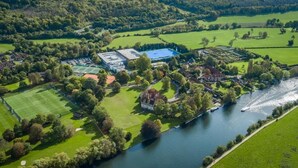 A riverside property with a large building, tennis courts, and a landscaped garden. - Bisham Abbey National Sports Centre  (Bisham)
