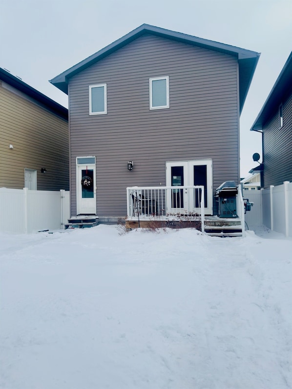 A two-story residential building with a front porch and a garage.