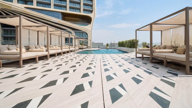A rooftop pool area with lounge seating and a view of a high-rise building. - 6th Floor Mercury Suite Apartment with Pool Access (Saint Julian's)