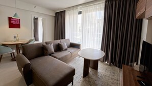 Een moderne woonkamer met een bank, een ronde tafel en een televisie.