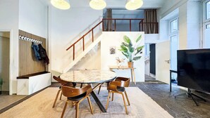 Ein modernes Interieur mit Essbereich, Treppe und Flachbildfernseher.