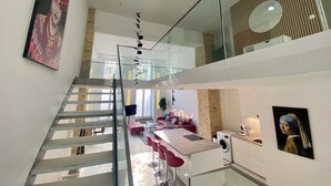 A modern interior with a staircase, a kitchen area, and a dining space. - Design Loft with Pool Table for 6 (Berlin)