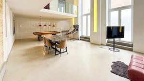 A modern living space with a dining area, a pool table, and a television. - Design Loft with Pool Table for 6 (Berlin)