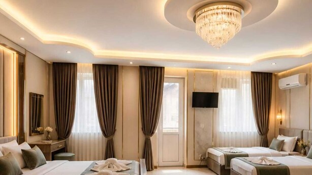 A hotel room with two beds, a TV, a chandelier, and a large window with curtains. - Tutto Passa Hotel (Tbilisi)