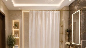 A modern bathroom with a bathtub, toilet, vanity, and a large mirror. - Tutto Passa Hotel (Tbilisi)