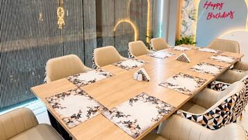 Un salón de conferencias con una larga mesa, seis sillas y un techo decorativo.