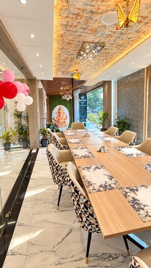 A conference room with a long table, chairs, and a mural. - BKRS Hotel (Varanasi)