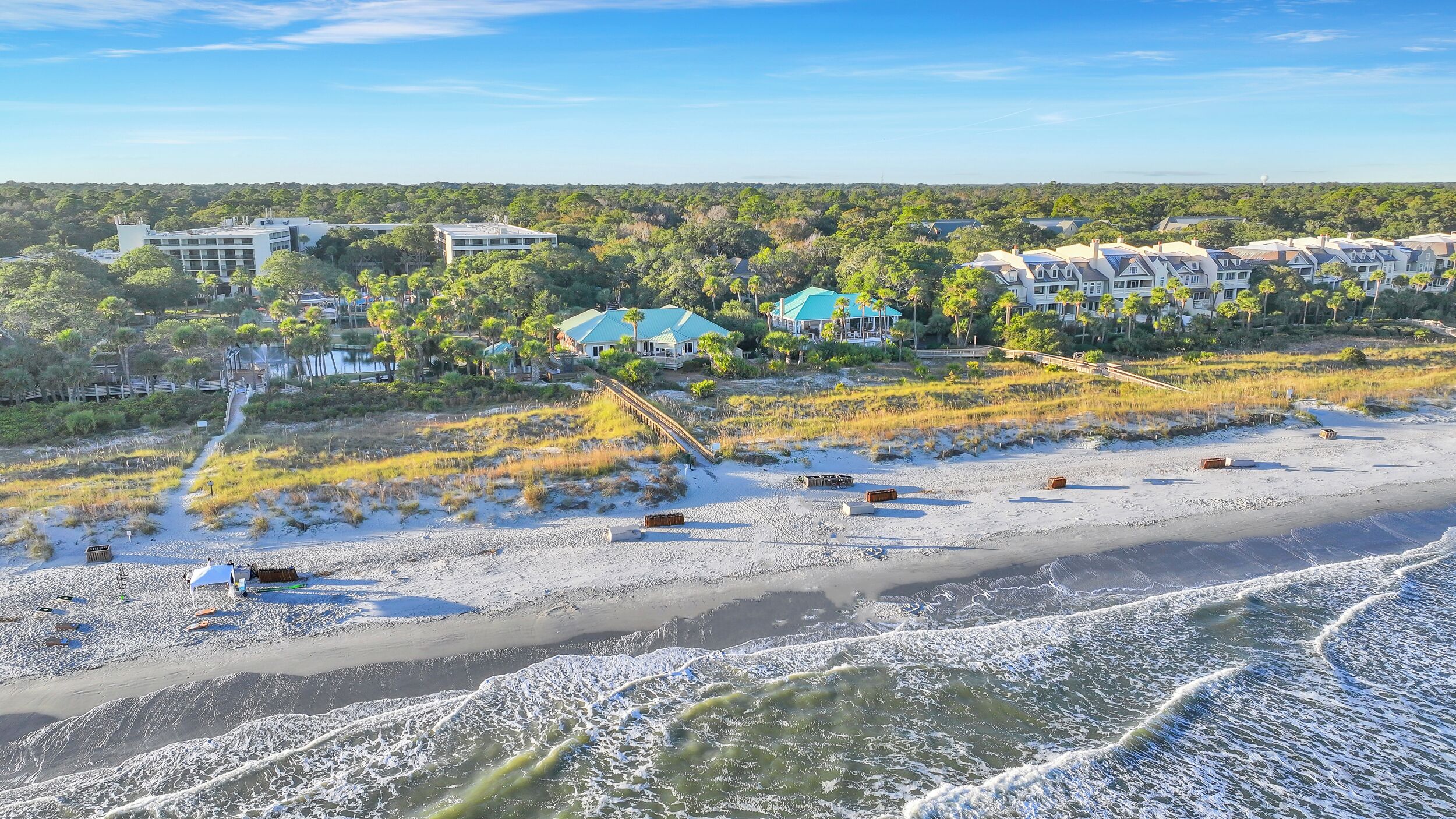 Un resort costero con propiedades frente a la playa, un paseo marítimo y vistas al océano.