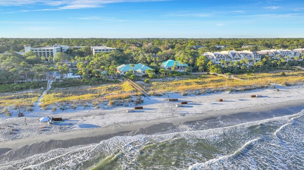 Ein Küstenresort mit Strandhäusern, einer Promenade und Blick auf den Ozean.