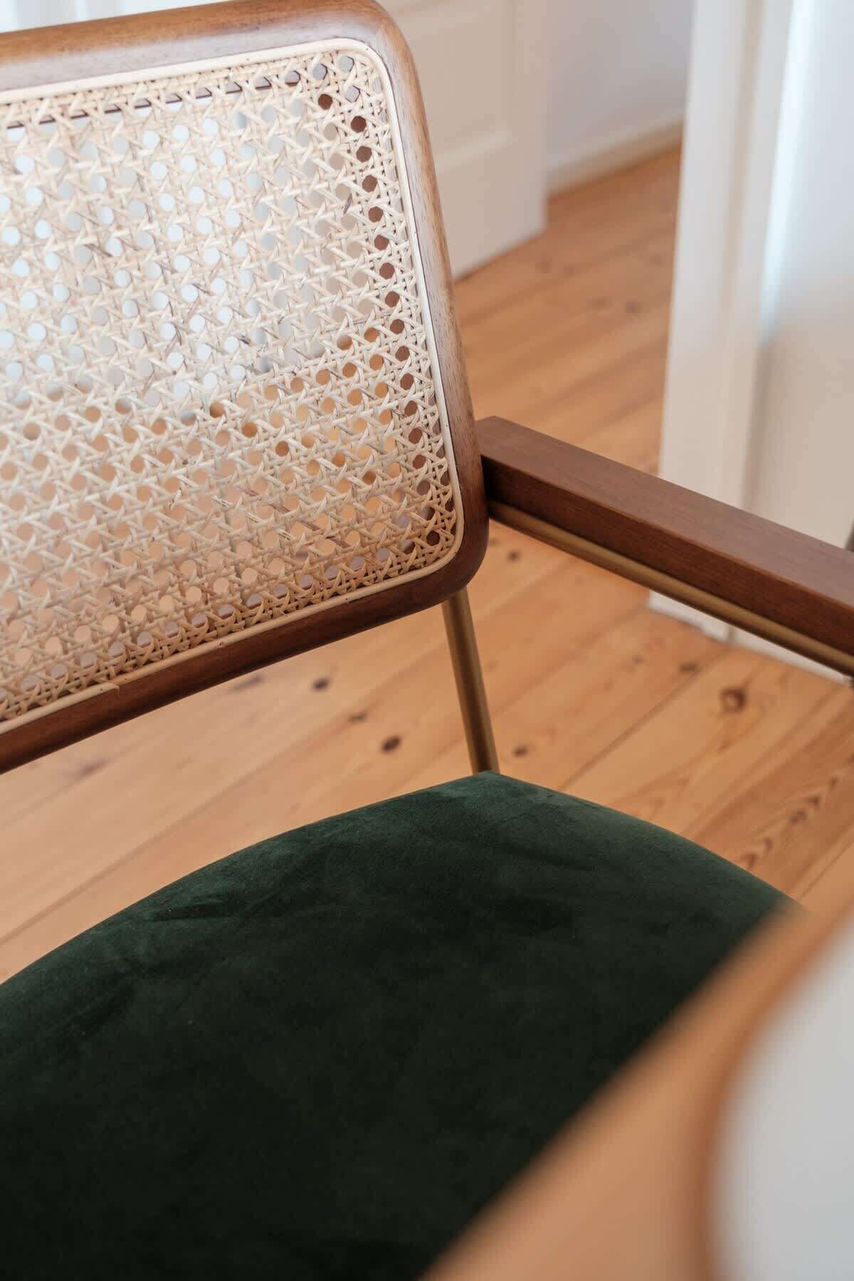 A chair with a woven backrest and a green cushion.