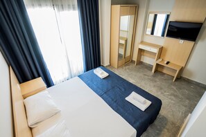 A hotel room with a bed, a desk, a mirror, and a TV. - m2 otel (Bodrum)