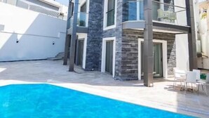 A multi-story building with a pool, balconies, and a modern architectural design. - m2 otel (Bodrum)