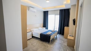 A hotel room with a bed, bedside tables, a desk, and a wardrobe. - m2 otel (Bodrum)