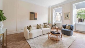 A living room with a sofa, armchair, coffee table, and a chessboard. - Elegant 1-Bedroom apartment in Bath - VAT Q (Bath)