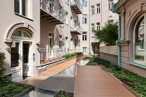 A modern building with a central courtyard, balconies, and a reflective water feature. - Exceptional Prague 1 Apt. in the City Center by Easybnb Premium (Prague)