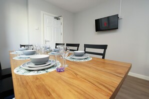 Een eettafel gedekt met borden, glazen en een decoratief glazen middelpunt.