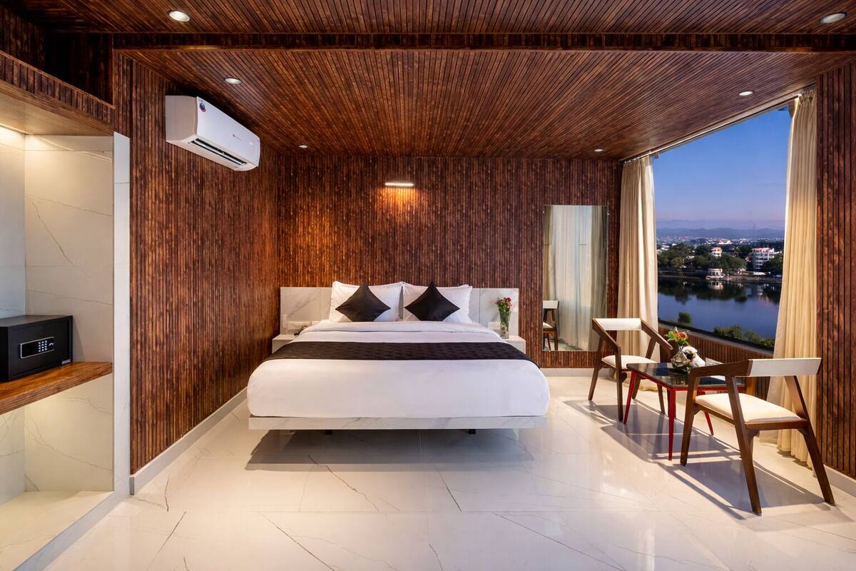 Habitación de hotel moderna con una cama grande, un escritorio y vistas a un lago.
