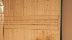 Eine Saunabank aus Holz mit einem Holz-Eimer.